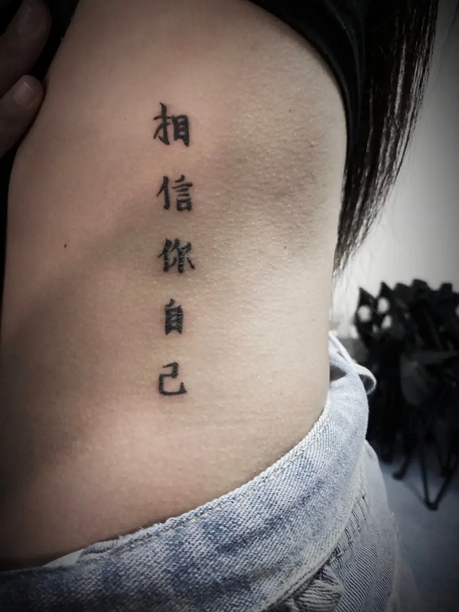 รอยสักตัวอักษรจีนข้างลำตัว 'เชื่อมั่นในตัวเอง'