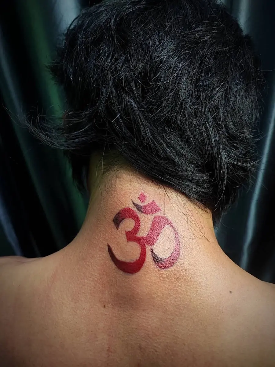 รอยสักสัญลักษณ์โอมสีแดงด้านหลังคอ